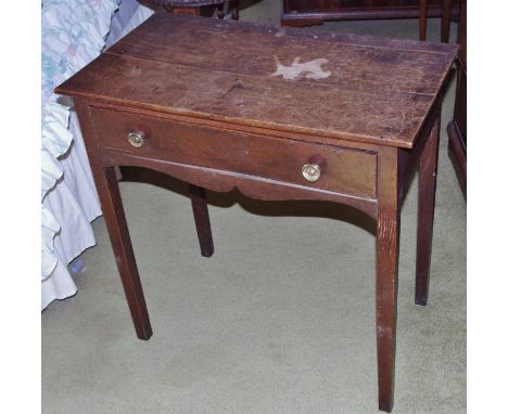 A George III oak side table, rectangular oversailing top above a long drawer, shaped apron, brass drum handles, tapered squar