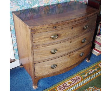 A George III mahogany bow fronted bachelor's chest, slightly over sailing top above a slide and three long graduated cockbead