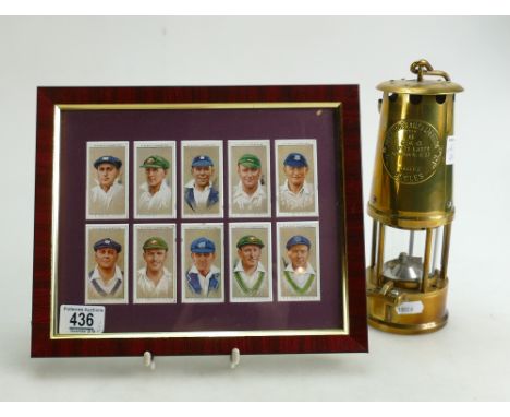 A brass Eccles miners lamp and Players Cricketer cigarette cards mounted in frame. (2)