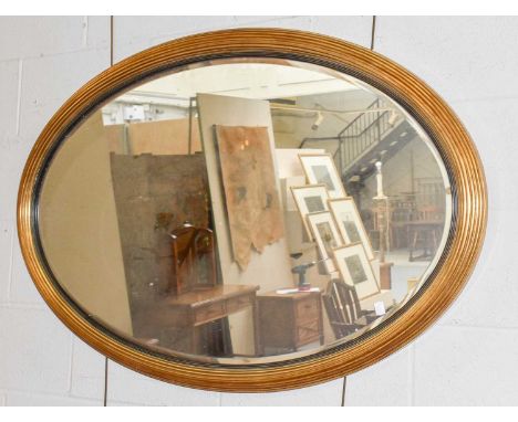 An oval hanging wall mirror in reeded gilt frame, 122cm by 78cm