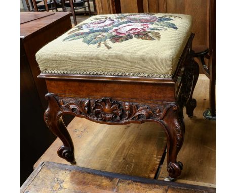 A Victorian carved walnut stool, with embroidered seat hinging to reveal a lined interior, raised on scroll supports, 42cm sq