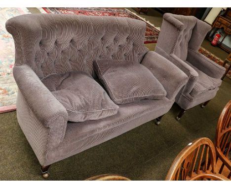 A Edwardian button back drop arm two seater sofa, 145cm by 78cm by 84cm, raised on capped tapering supports; together with a 