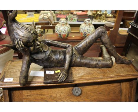 A bronze sculpture of an elf reading 
