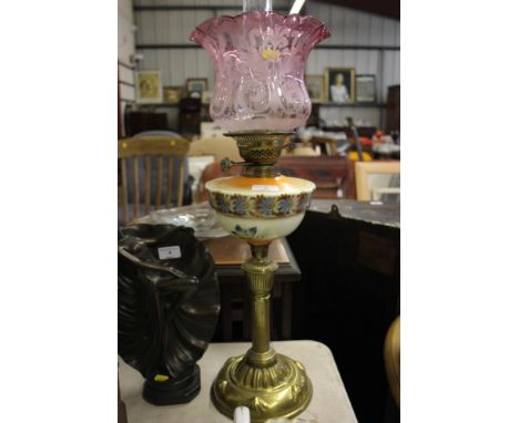 A Victorian oil lamp with etched cranberry glass shade