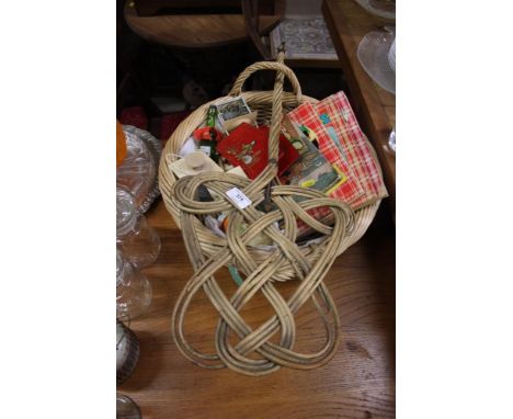 A wicker basket containing children's books; two small candle lanterns; a carpet beater etc.