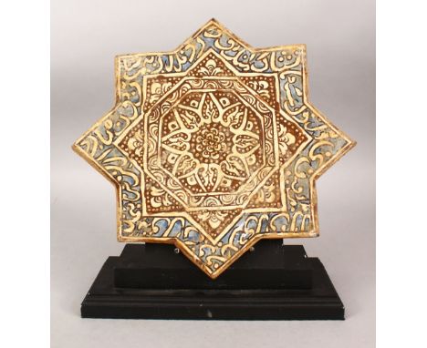 AN ISLAMIC EIGHT-POINTED STAR TILE with stand, the tile with calligraphy, 32cm x 32cm.