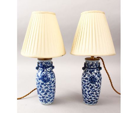 A PAIR OF 19TH CENTURY CHINESE BLUE &amp; WHITE PORCELAIN VASES / LAMPS, decorated with formal scrolling vine and rosette, wi