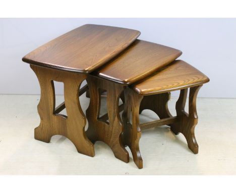Ercol elm nest of tables having pierced lyre supports unite by stretchers. Measures 41 x 56 x 35cm.