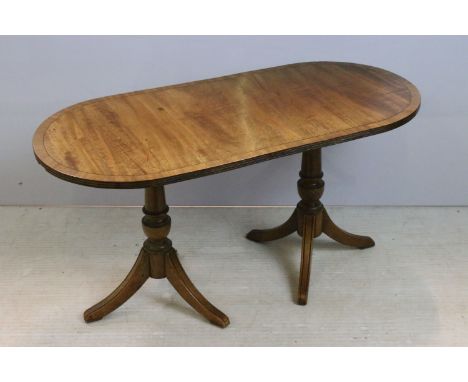 20th Century mahogany miniature twin pedestal table having an oval top raised on two columns with tripod supports. Measures 4