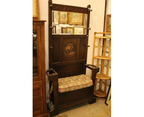 1930s oak hall stand bench having a panelled back with carved ship, bevelled glass mirror and turned hooks, with cushioned se