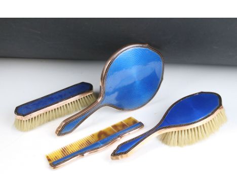 Early 20th century four piece yellow metal dressing table set with blue guilloche enamel backs, mirror measures 25cm long