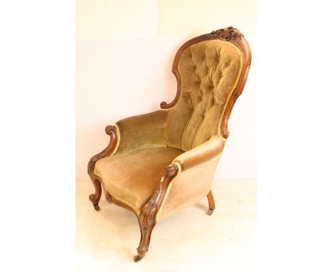19th Century Victorian button back nursing chair having carved foliates and velvet upholstery, raised on ceramic castors. Mea
