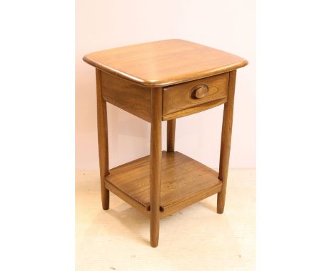 Ercol elm bed side table having single drawer to top with lower tier shelf below raised on turned legs. Measures 64 x 44 x 44