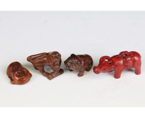 Four carved miniature wood netsuke figures to include signed Buddha head, money cow, dog and panther