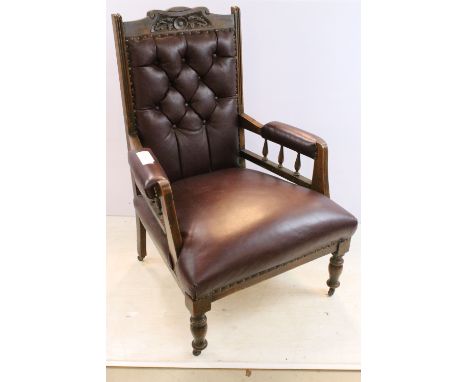 Oak deep button back leather arm chair on turned legs with casters, floral carved top