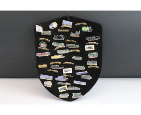 A collection of Railway enamel badges to include steam, diesel and electric train examples, mounted upon a cloth covered shie