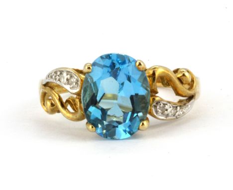A 9ct yellow gold ring set with an oval cut blue topaz and diamond set shoulders, (N.5).
