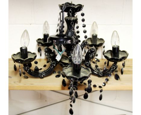 A black glass chandelier light fitting and two table lamps.