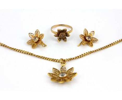 A yellow metal (tested high carat gold) suite of jewellery comprising a pendant and chain, earrings and ring, set with white 