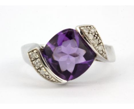 A 9ct white gold ring set with a cabochon cut amethyst and brilliant cut diamond set shoulders, (N).