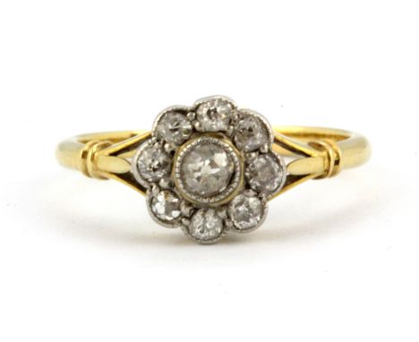 An 18ct yellow gold diamond set daisy cluster ring, (K).