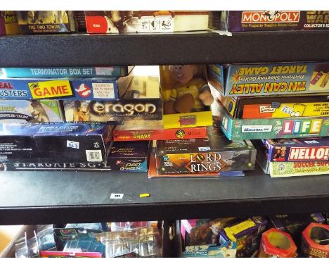 A shelf containing a quantity of board games to include Stargate SG-1, Lord of the Rings, The Simpsons, Tin Can Alley, Bookie