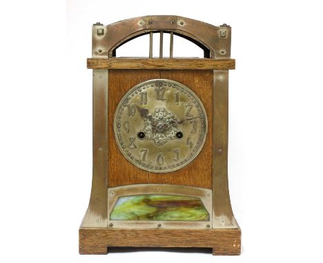 A Secessionist oak and brass-mounted mantel clock,with an embossed dial, with a mottled glass panel below,36cm highCondition 