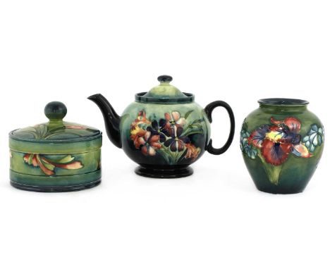 A Moorcroft teapot, tubelined with flowers,14.5cm high,a pot and cover, 11cm high13cm diameter, anda vase, 12cm high,two with