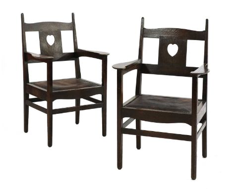 A pair of rare Arts and Crafts oak armchairs, by C F A Voysey (1857-1941), c.1902, each with leather and studded drop-in seat