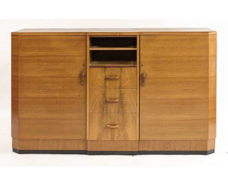 An Art Deco Heal's walnut sideboard,with an inverted front with canted corners, centred with five drawers, with ivorine butto