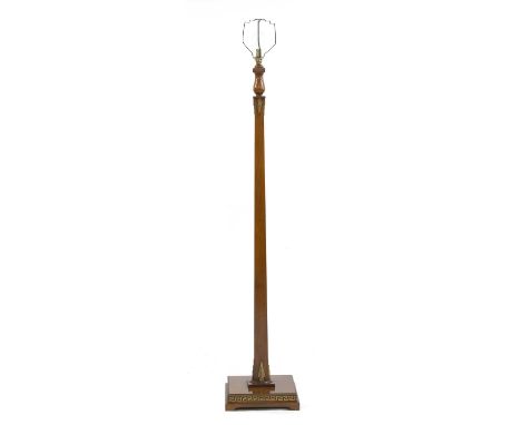 An Art Deco walnut standard lamp,of tapering form, mounted with gold arrows, a baluster top, with Greek key banding on the pl