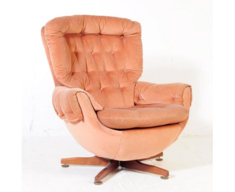 British Modern Design - A retro mid 20th century swivel desk egg easy lounge armchair. Having button back, backrest and cushi
