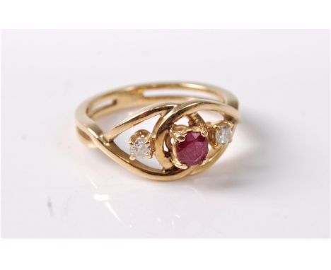 A ruby and diamond ring, the central round ruby claw mounted to two overlapping loops of yellow metal each holding a small ro