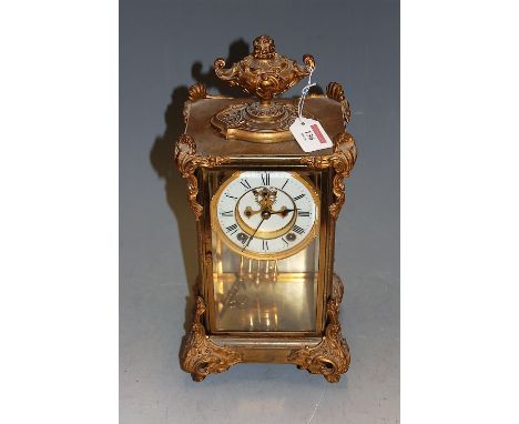 A late 19th century gilt brass cased four glass mantel clock, having white enamel, visible escapement, spring driven movement