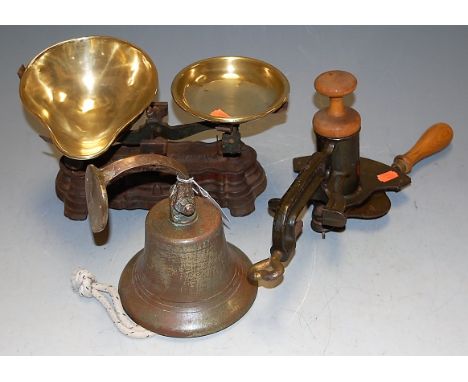 A cast iron and brass set of weighing scales; together with a brass bell; and a 'Magic' marmalade cutter (3)