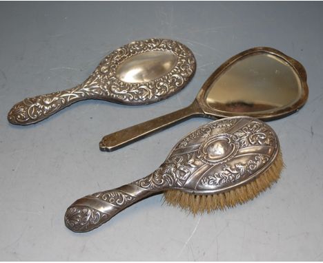 An Edwardian embossed silver backed hair brush together with hand mirror, and one other later engine turned silver backed han