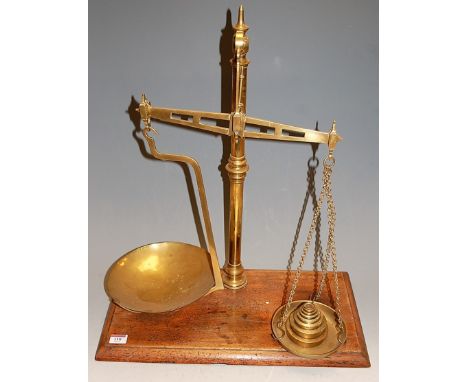 A Victorian brass beam scale, with weights and on mahogany plinth