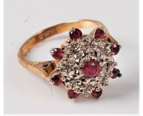 An 18ct ruby and diamond cluster ring, the central ruby surrounded by small round diamonds and an outer ring of small rubies,