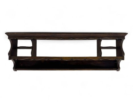 Late 19th to early 20th century hardwood wall rack, projecting cornice over scalloped open shelf, flanked by two open side co