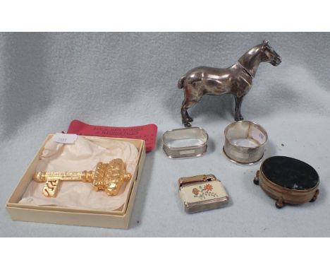 A WHITE METAL NOVELTY HORSE TABLE LIGHTER (?) with two silver napkin rings, another lighter and other sundries
