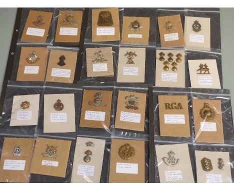 A collection of British Army cap badges / collar badges to include 5th Dragoon Guards, Devonshire Regt, Royal Irish Regiment,