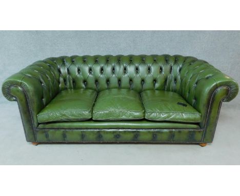 A three seater Chesterfield sofa in green leather buttoned upholstery. H.76 W.207 D.96cm 