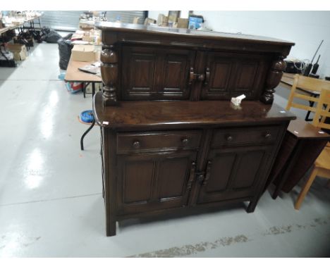 A dark stained Ercol style court cupboard