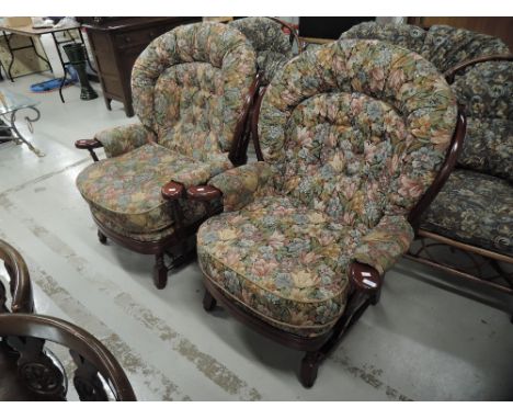 A pair of dark stained Ercol style armchairs