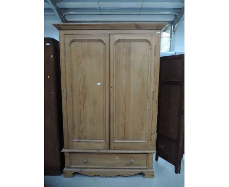 A stripped pine wardrobe on drawers base