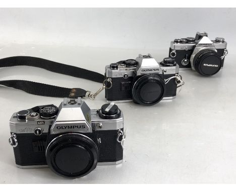 Two Olympus OM-10 camera bodies and one Olympus OM-2 body, 50mm F/1.8 (on-/off switch missing) along with an Olympus case, al