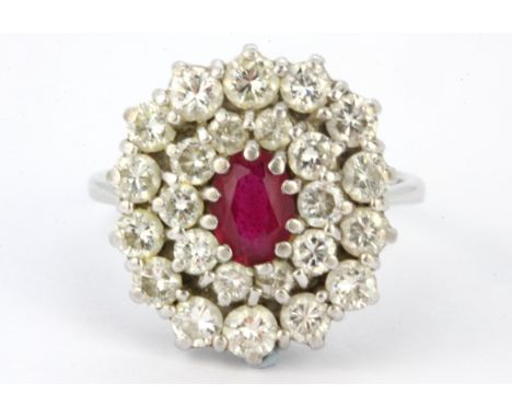 A white metal (tested minimum 18ct gold) cluster ring set with an oval cut ruby and brilliant cut diamonds, L. 2 x 1.7cm, (S)