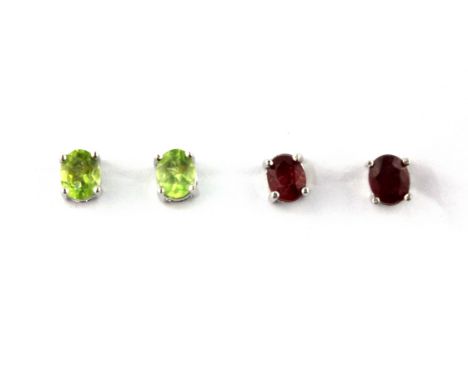 A pair of 925 silver ruby set stud earrings together with a further pair of 925 silver peridot set stud earrings.