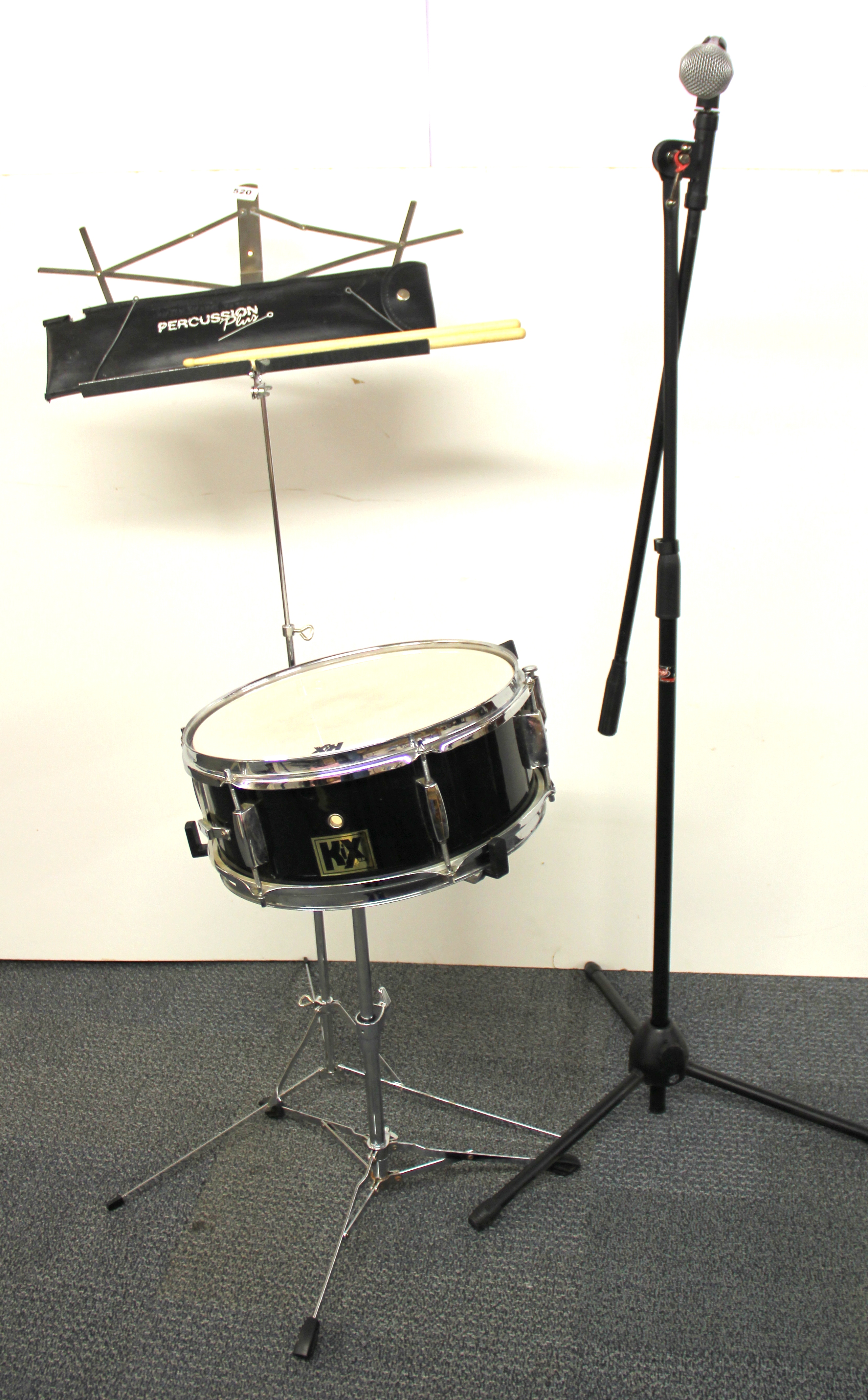 A snare drum, music stand and microphone stand.