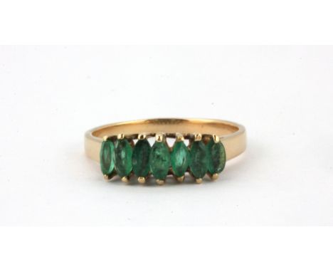 A yellow metal (tested minimum 9ct gold) ring set with marquise cut emeralds, (R).